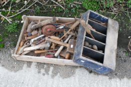 A collection of vintage wood-working tools. To include chisels, hand drills, a saw, a plane, and
