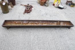 A heavy cast iron trough. With drainage hole to one end, and a crack and riveted repair 1/5 from the