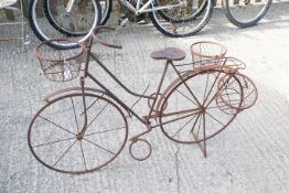 A metal garden plant pot holder in the form of a push bike. H77cm All items in this auction are sold