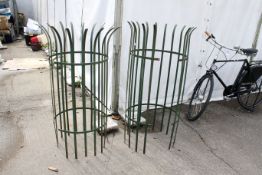A pair of green painted iron strapwork crown top tree gaurds. H130cm & 135cm, C50cm. All items in