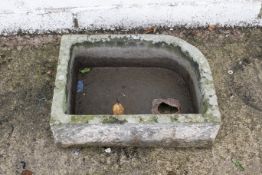 An antique carved stone trough or pump basin. Rectangular form with one rounded corner, with