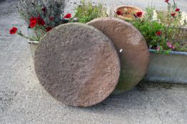 A pair of large stone disks. Diameter 70cm All items in this auction are sold as seen, We are unable