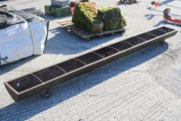 A large metal feed trough. H22cm x W303cm x D30cm