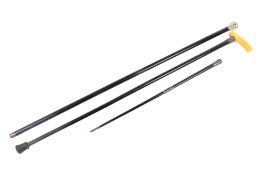 Two white metal mounted and ebonized walking sticks and a similar swagger stick.