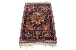 A rust red and green patterned prayer rug.