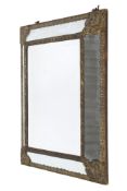 A Louis XV style repousse brass cushion framed wall mirror.