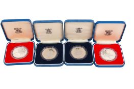 Four commemorative silver proof coins.