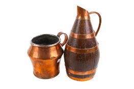 A vintage copper and oak cider barrel and a copper jug.