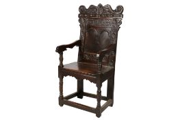A late 17th century and later Wainscot type carved oak armchair.