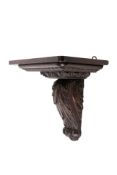 A 17th century and later carved oak wall bracket.