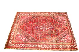 A Persian style woollen rug.