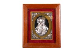 A framed white metal religious icon.