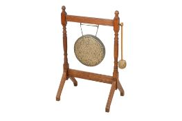 An early 20th century brass dinner gong on an turned oak stand with beater. Gong 30cm diameter.