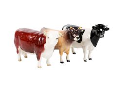 Three vintage Beswick ceramic figures modelled as cattle.