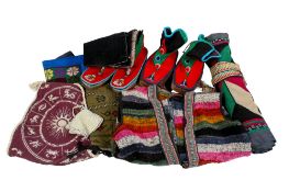 A collection of assorted ethnic textile items. Including a pair of Tibetan boots, etc.