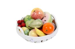A modern continental bowl of ceramic fruit. Including a slice of melon, apples, etc.