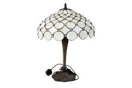 A modern 'Tiffany' style table lamp. Having a large leaded glass shade, raised on a square base.