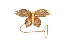 A yellow metal filigree butterfly brooch.