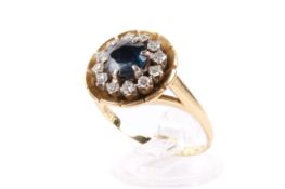 An 18ct gold cluster ring. Set centrally with one round faceted sapphire of 1.
