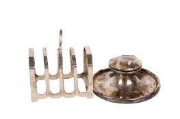 A silver toast rack and a weighted inkwell.