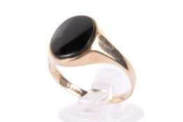 A 9ct gold and onyx ring. The oval stone of circa 1.2cm x 1cm, size R, gross weight 2.2g.