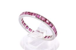 A full eternity ring set with square faceted rubies. Metal not marked, tested as platinum.
