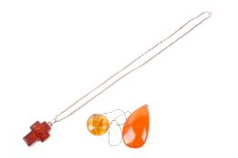 Three amber pendants. One of pale colour with inclusions, diameter circa 2.
