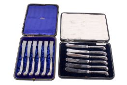 Two boxed sets of six silver handled butter knives.