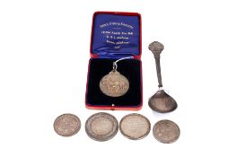 Five silver medallions and a spoon from the 1930s and 1940s.