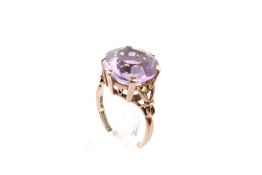 A 9ct gold and amethyst dress ring. The round faceted stone circa 1.