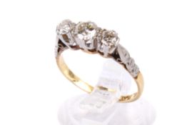 A yellow metal three-stone diamond ring. Set with round brilliant cut diamonds of 0.