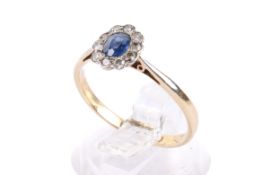 A diamond and sapphire cluster ring. Set centrally with one oval faceted blue sapphire of 0.