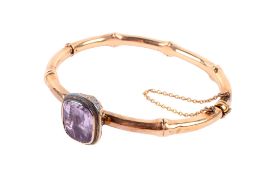 An early 20th century bangle. Set with one rectangular cushion shaped amethyst measuring circa 13.