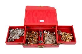 A red jewellery box containing an assortment of costume jewellery.
