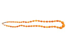 A butterscotch amber bead necklace. The oval beads from circa 0.8cm x 0.4cm to 1.6cm x 1.