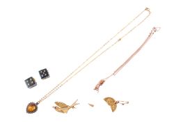 A broken sovereign, a small bird brooch, pendant and a pair of dice.