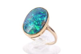 A yellow metal and black opal dress ring.