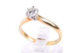 An 18ct gold diamond solitaire ring. The round cut diamond of circa 0.3-0.
