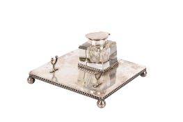 A matched silver inkwell and stand.