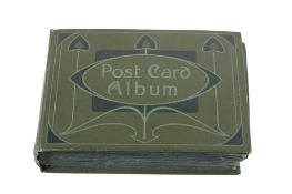 A small green postcard album of early to mid-20th century postcards.