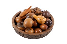 A group of hand turned treen fruits within an African wooden bowl. Including apples and pears, etc.