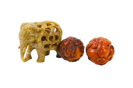 Two Japanese carved balls and a soapstone elephant.