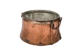 A large antique copper cauldron pan with swing handles.