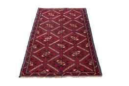 A small Afghan Turkmen style wool rug on blue and red ground.