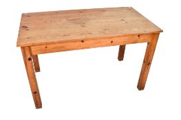 A rectangular pine kitchen table. Raised on square supports.