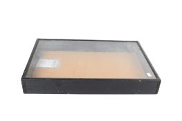 A lockable hinged table top glass display case.