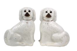 A pair of Staffordshire pottery Comforter Spaniels having glass eyes.