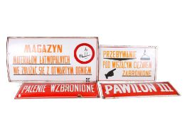 A collection of four assorted vintage Polish language enamel warning signs.