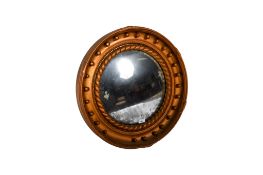 Convex circular Regency style wall mirror. Having a gold painted frame.
