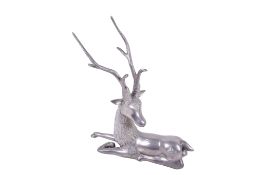 A modern cast metal figure of a recumbent stag.
